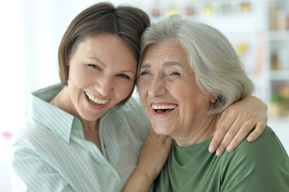 Senior woman and young woman smiling and embracing