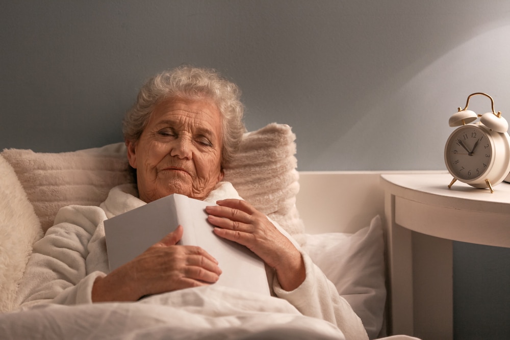 Senior woman falling asleep while reading in bed