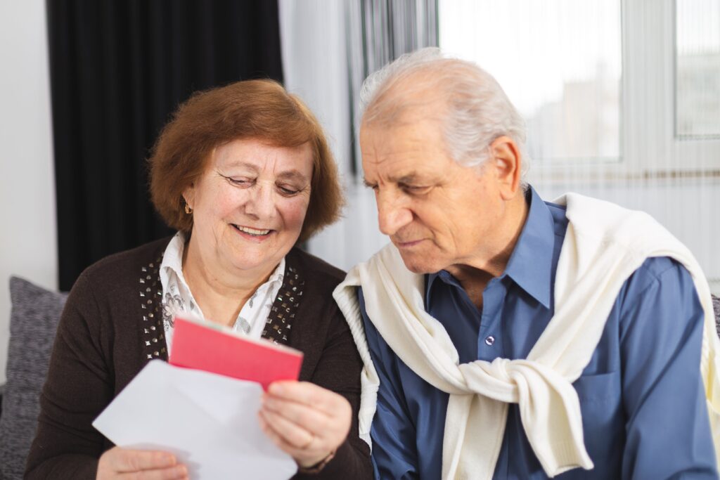 Smiling senior couple looking at card together