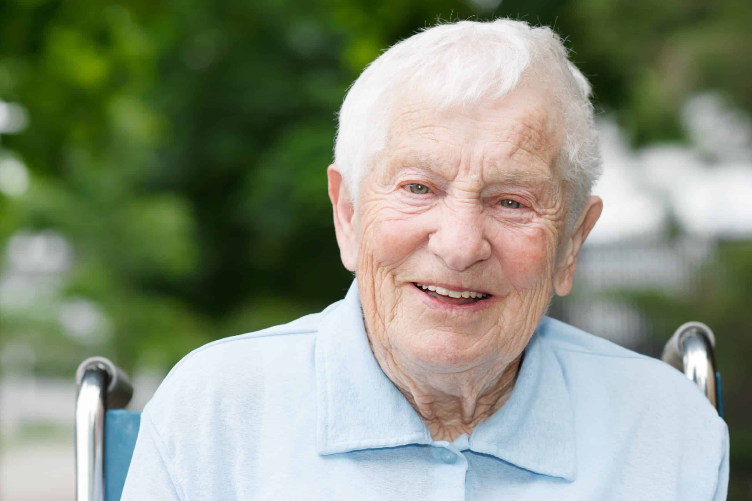 Portrait of smiling senior in wheelchair outdoors