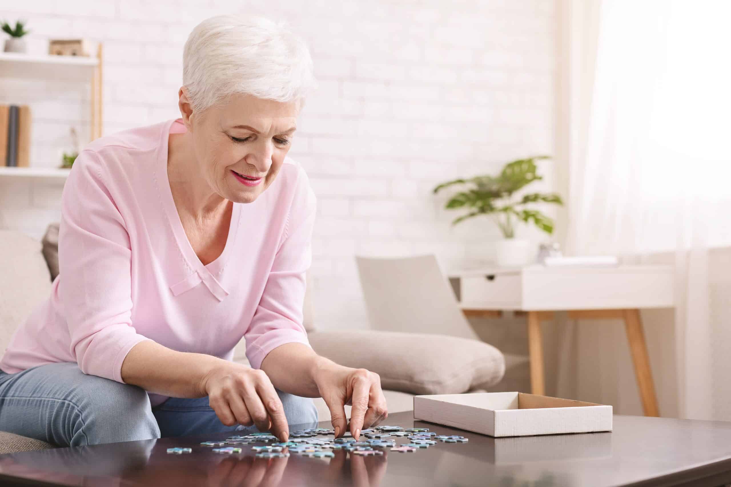 senior woman completing jigsaw puzzle