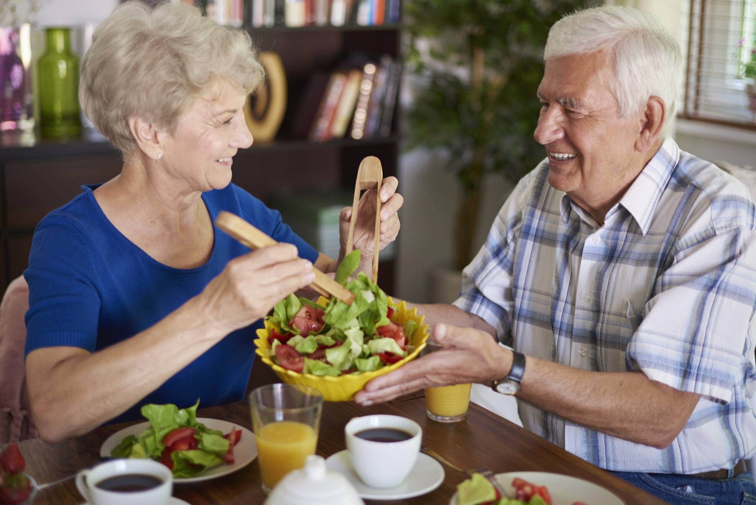 Senior couple smiling and eating salad