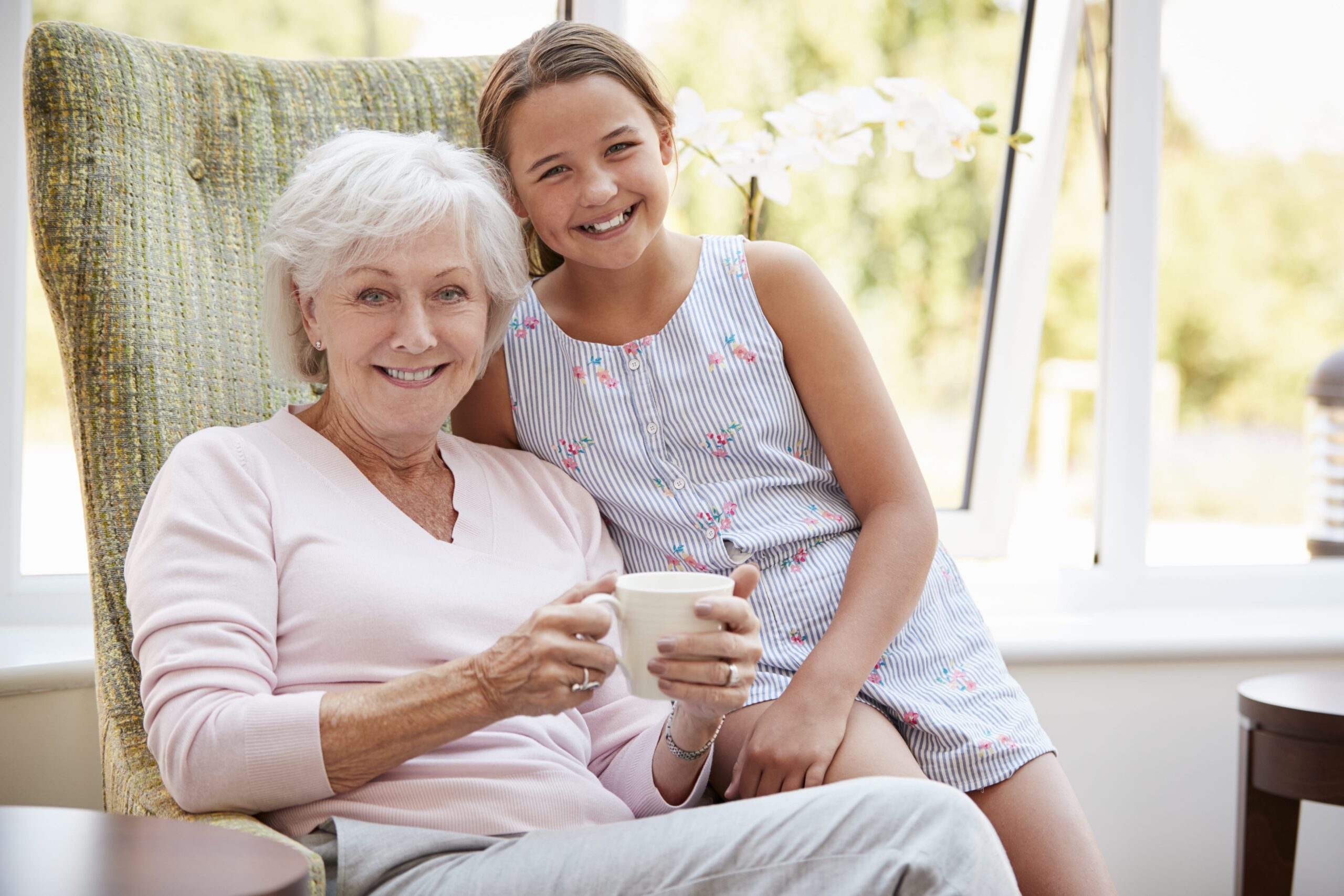 Smiling senior woman sitting with granddaughter