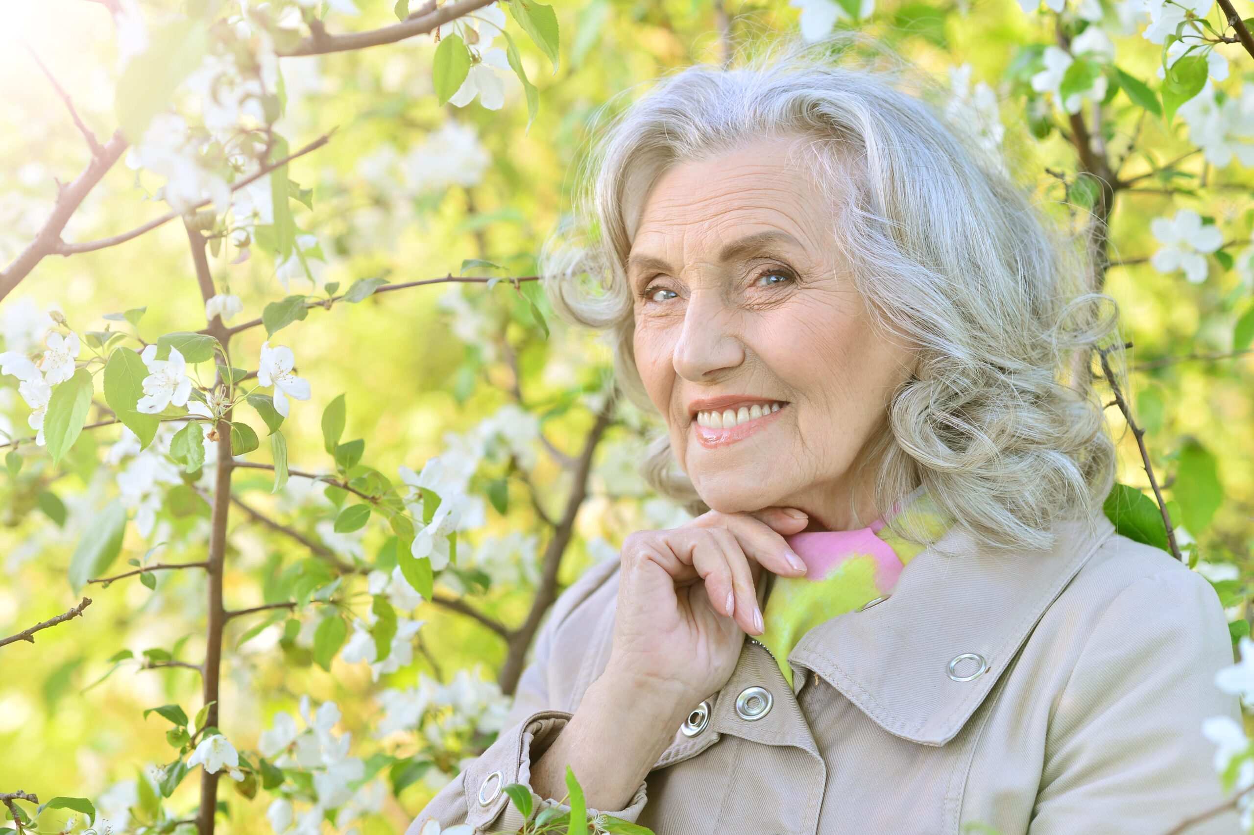 Portrait of smiling senior woman in front of tree